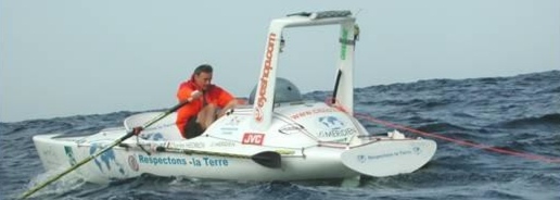 Photo d'un homme dans une embarcation sportive à rames au milieu de l'océan