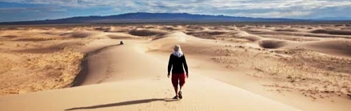 Photo d'un individu au milieu d'un désert de sable